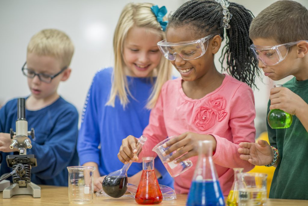 Kids doing chemistry experiments with beakers in a scouting merit badge class