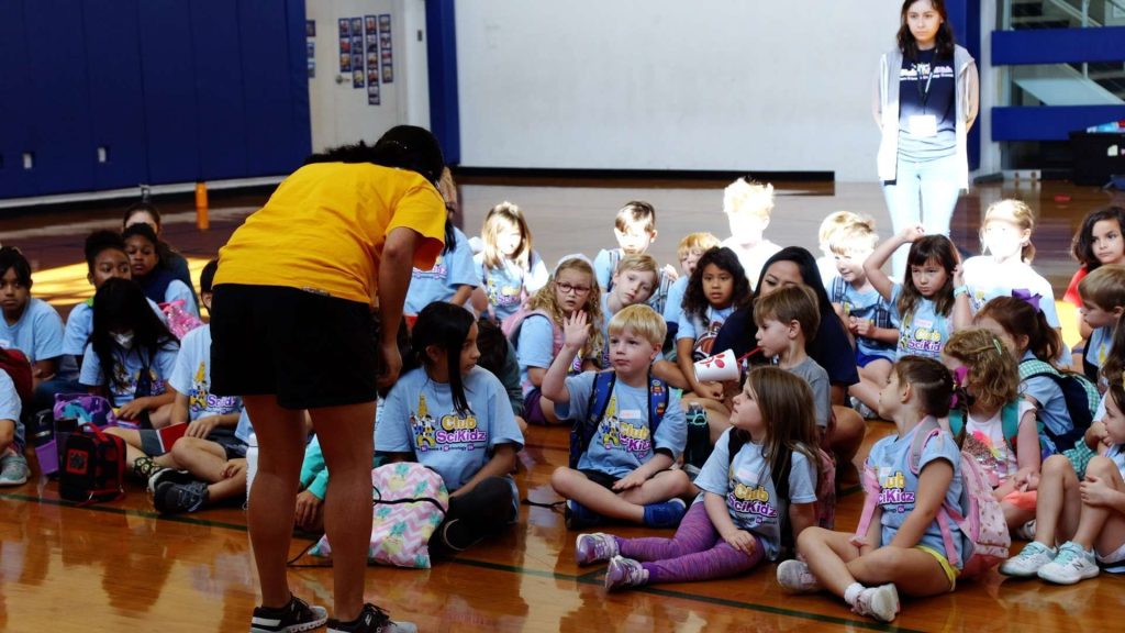 Summer Camp programs for kids counselor talking to a group of campers